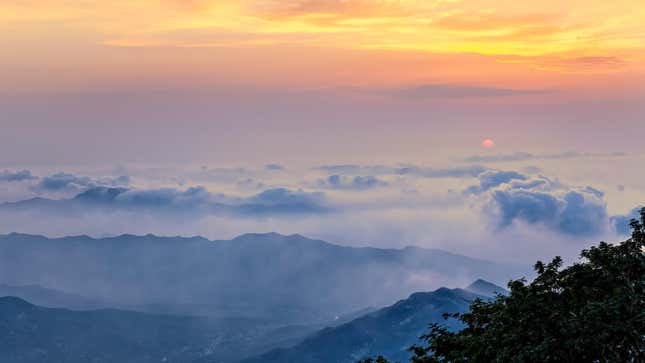 A photo of Mount Tai and its clouds captured at sunrise.